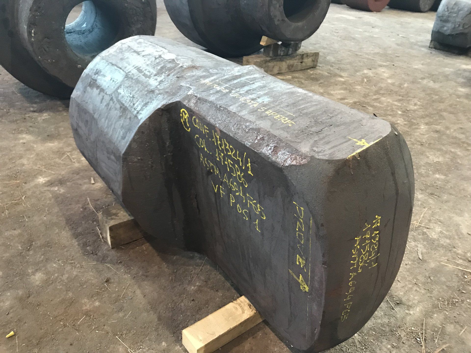 Un grande pezzo di metallo è appoggiato su un pallet di legno.