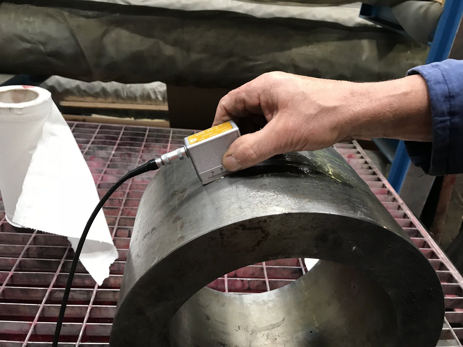 Una persona sta misurando un oggetto metallico con un dispositivo.