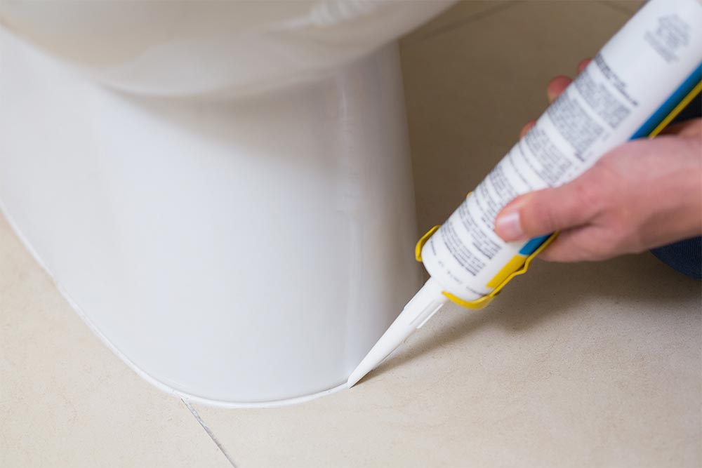 Handyman Re-Sealing A Toilet Base