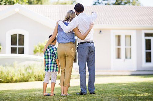 Family Standing in fron of a New Home