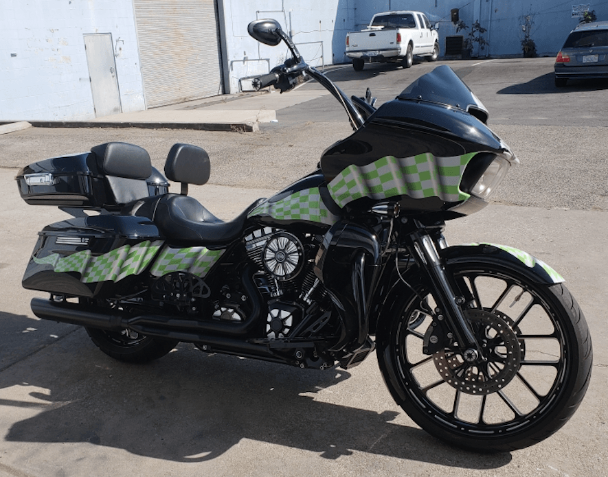 A black and green motorcycle is parked in a parking lot