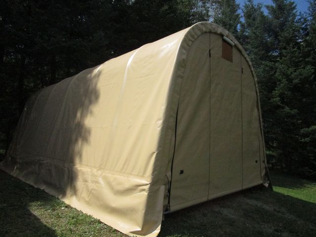 A large tent is sitting in the middle of a lush green field