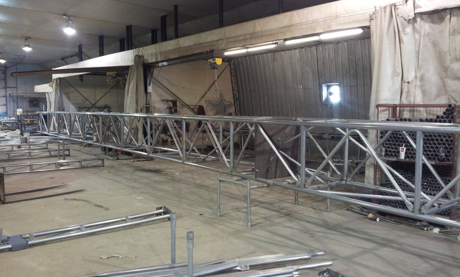 A large metal structure is being built in a factory.