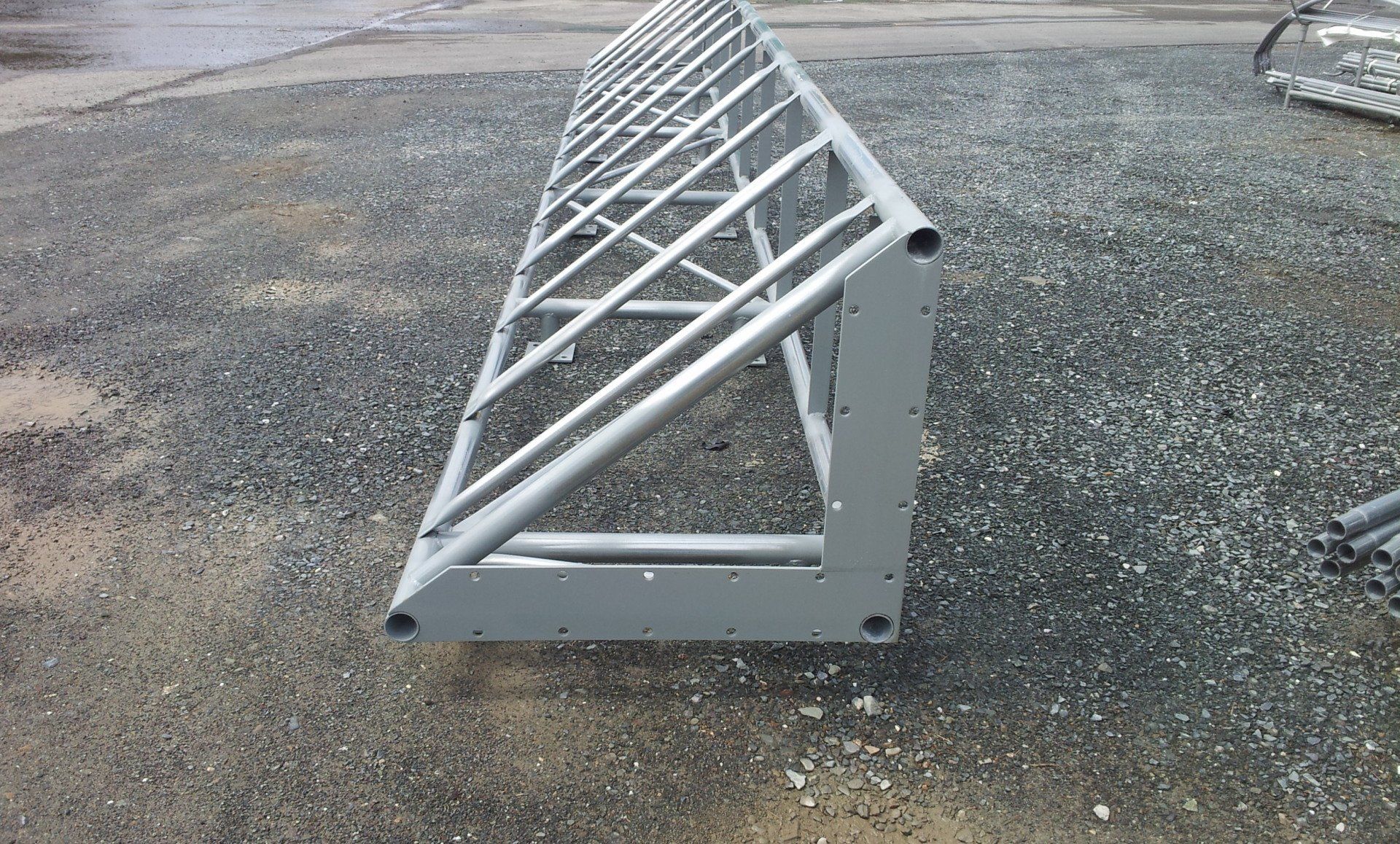A metal structure is sitting on a gravel road.