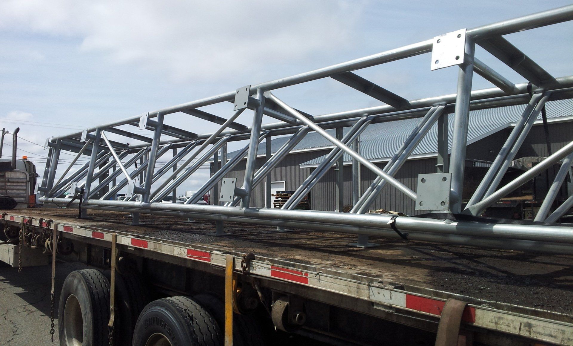 A large metal structure is on the back of a truck