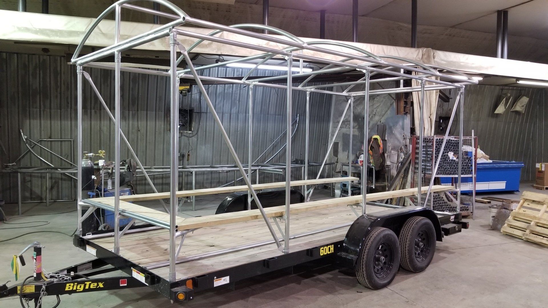 A trailer is being built in a garage with a metal frame.