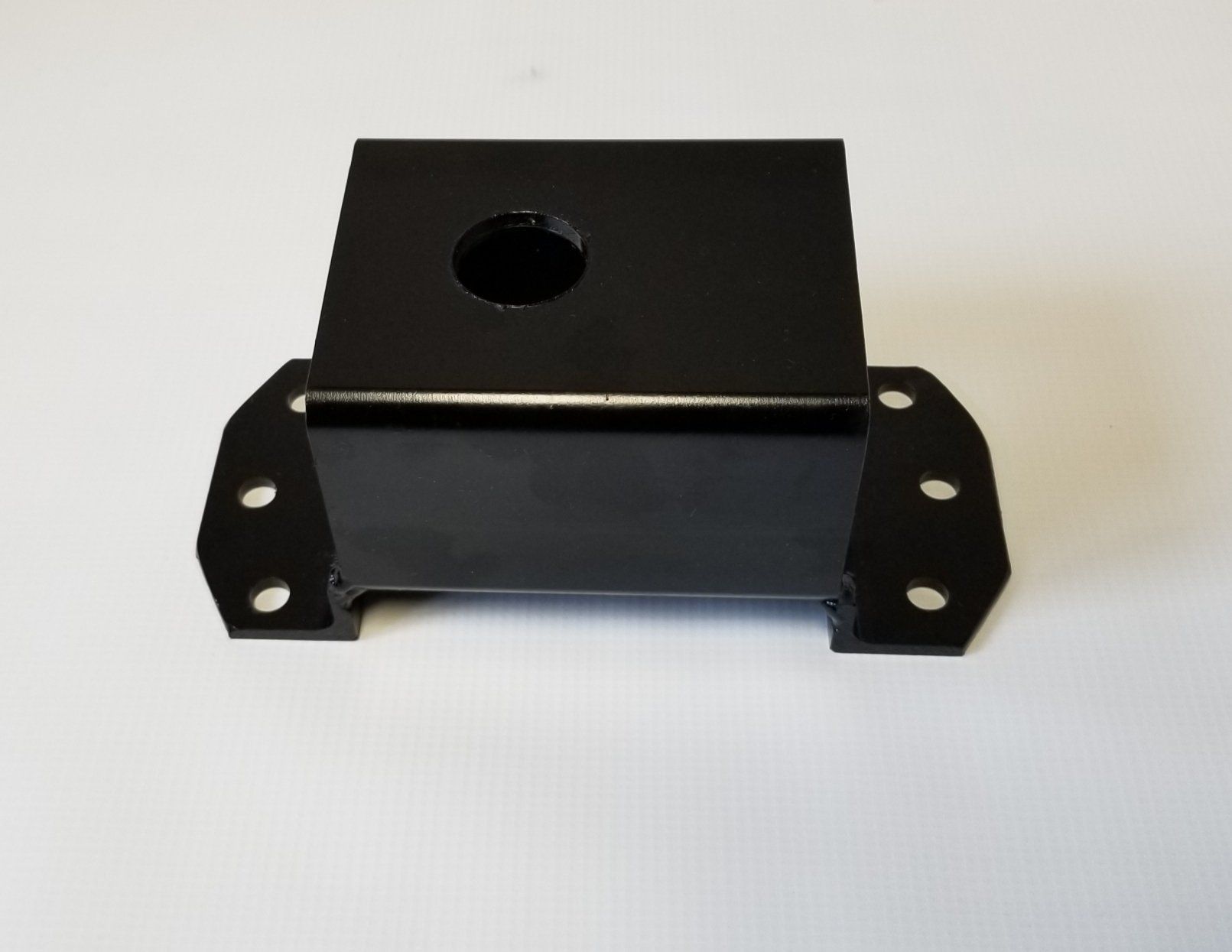A black metal block with a hole in the middle