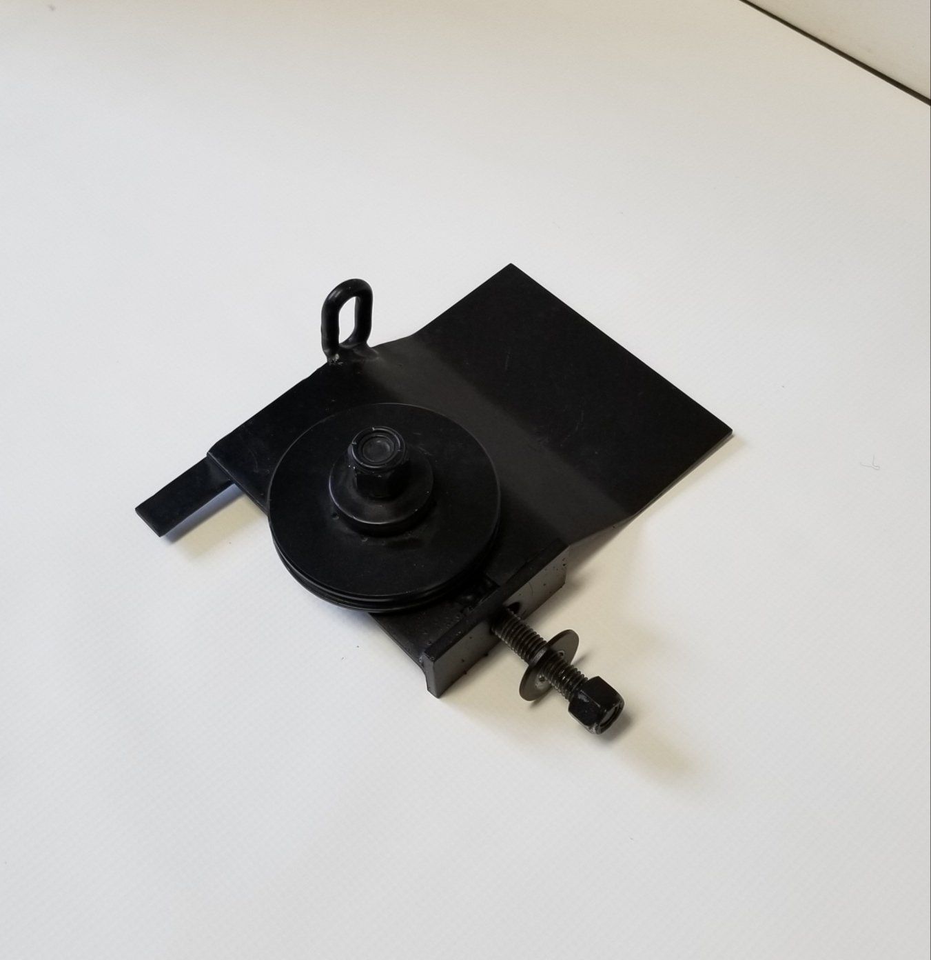 A black piece of metal with a screw on it