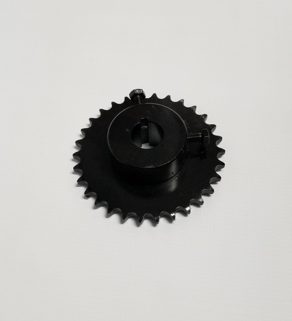 A close up of a black gear on a white surface