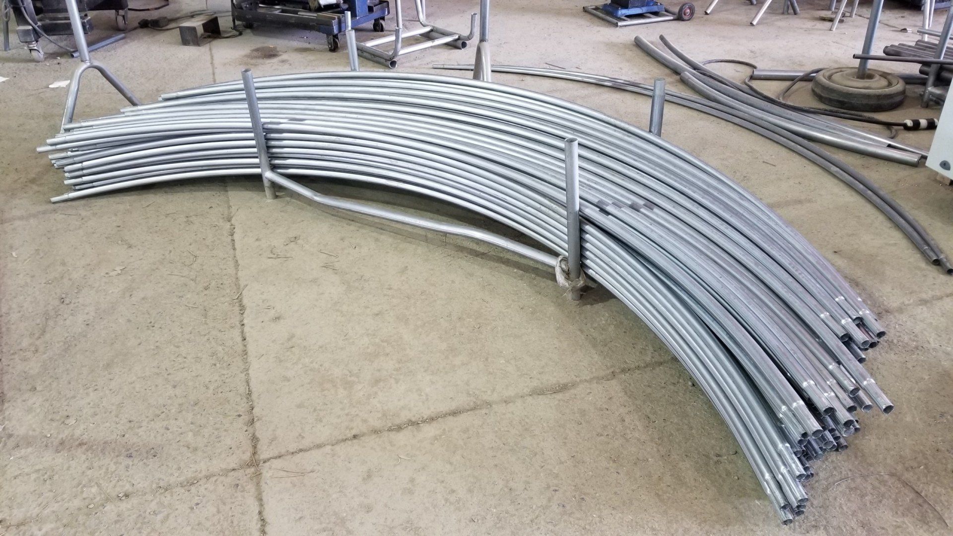 A bunch of metal pipes are stacked on top of each other on the floor.