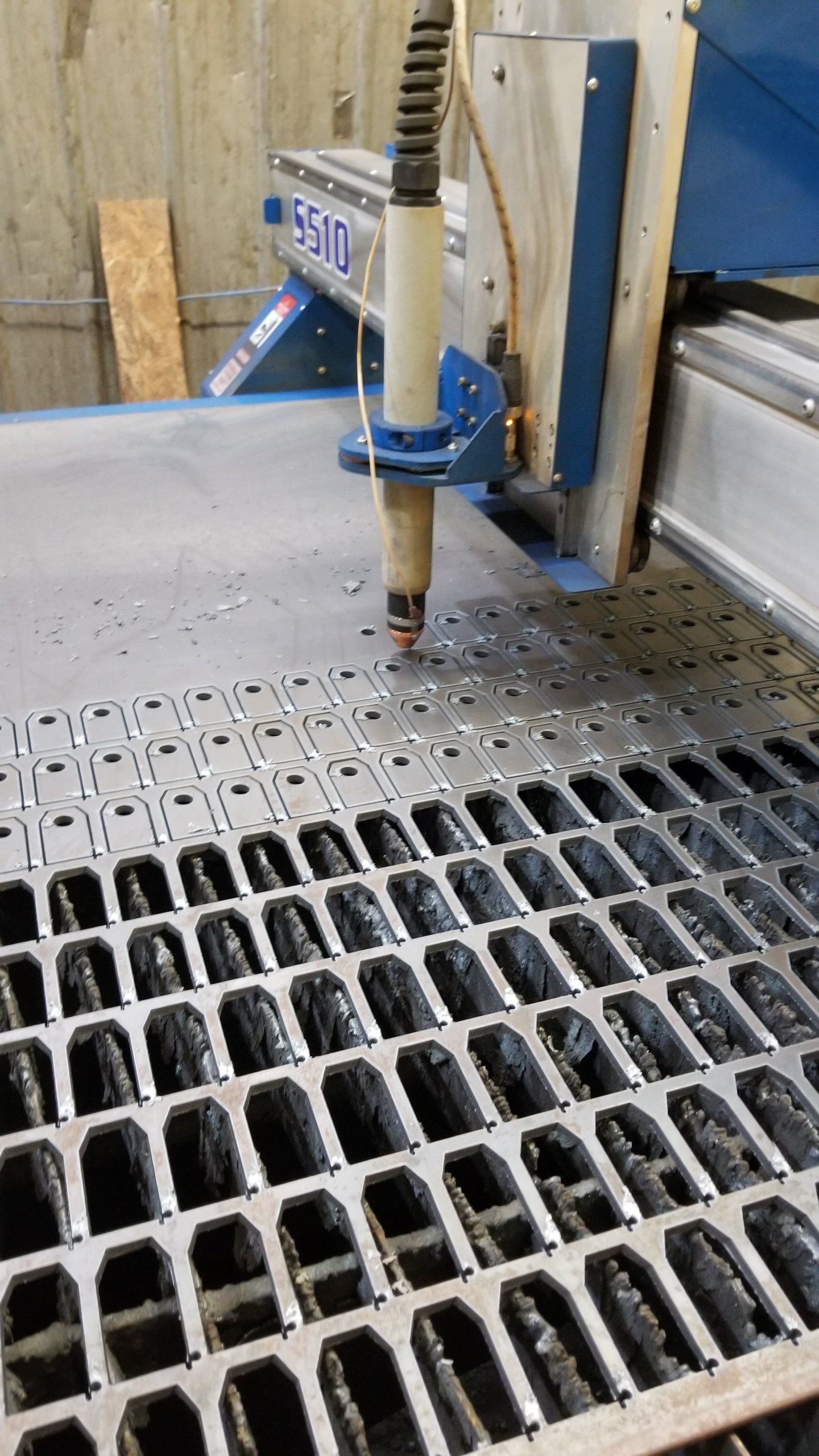 A machine is cutting a piece of metal on a table.