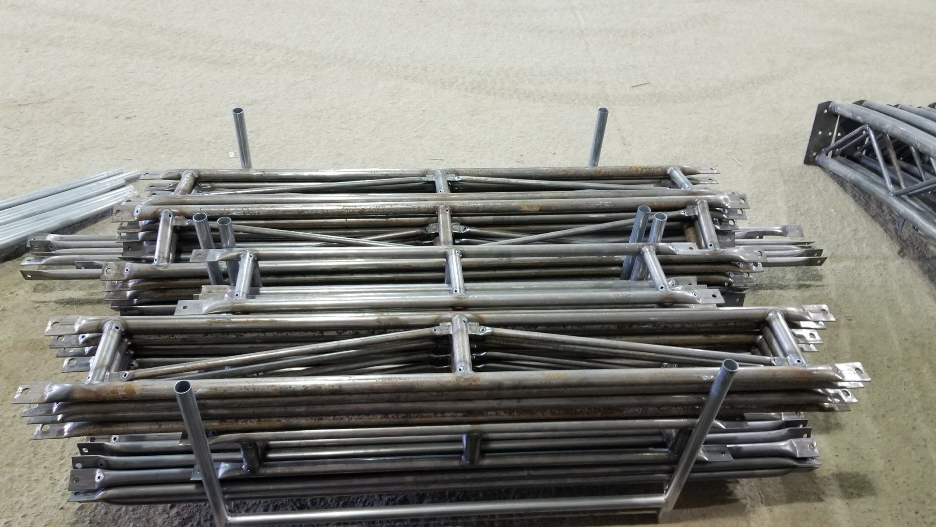 A bunch of metal pipes are stacked on top of each other on the ground.