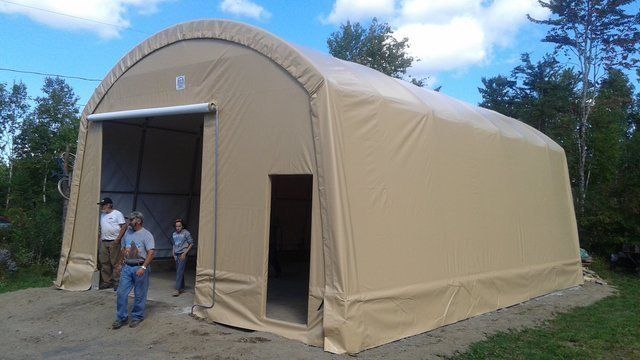 A group of people are standing in front of a large tent.