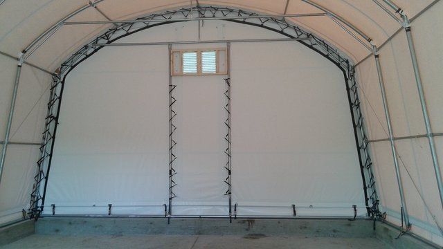 The inside of a large white tent with a window.