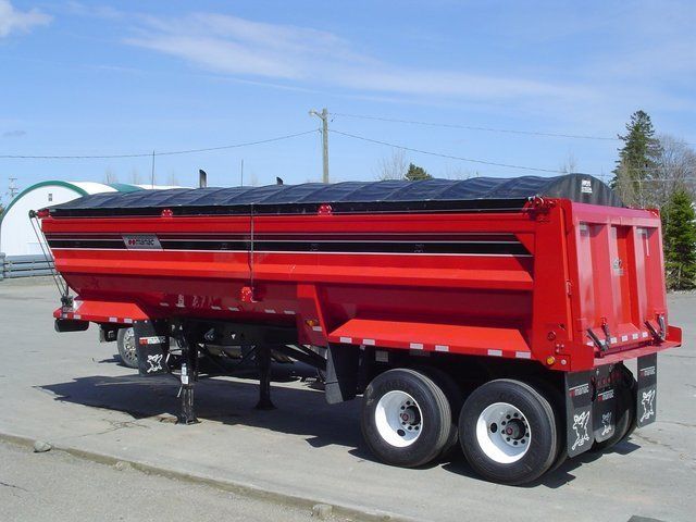 A red dump truck is parked in a parking lot