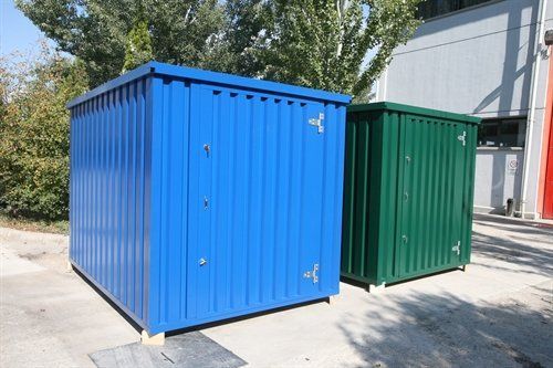 Blue and green metal storage containers outdoors. Cover-Tech Portable Containers.