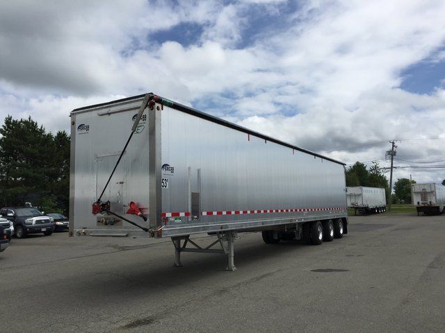 A silver semi trailer is parked in a parking lot.