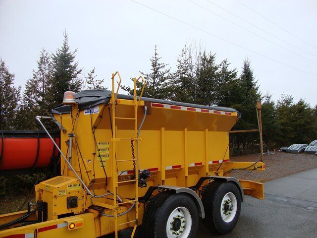 A yellow truck is parked on the side of the road