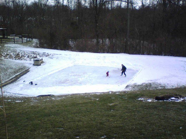 A man and two children are playing in the snow