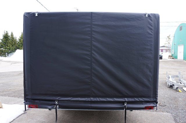 A black trailer is parked in a parking lot.