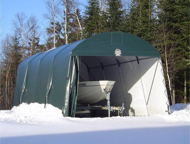 Green fabric shelter with a white boat and trailer in the snow. Trees in background. Cover-Tech Portable Garages.