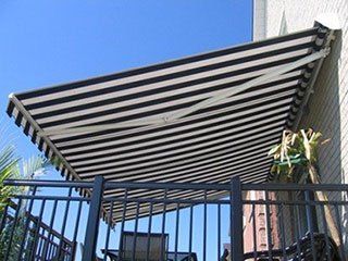 A black and white striped awning is covering a balcony.
