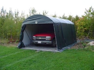 A red truck is parked in a green garage.