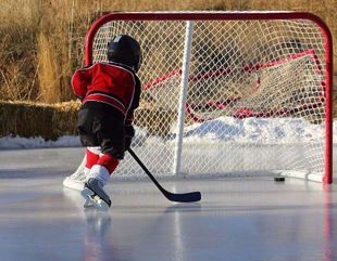 A young boy is playing ice hockey on a rink.