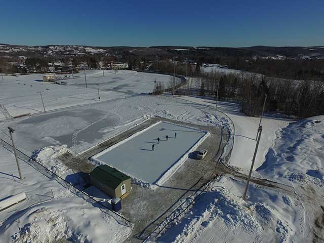 An aerial view of a hockey rink in the snow