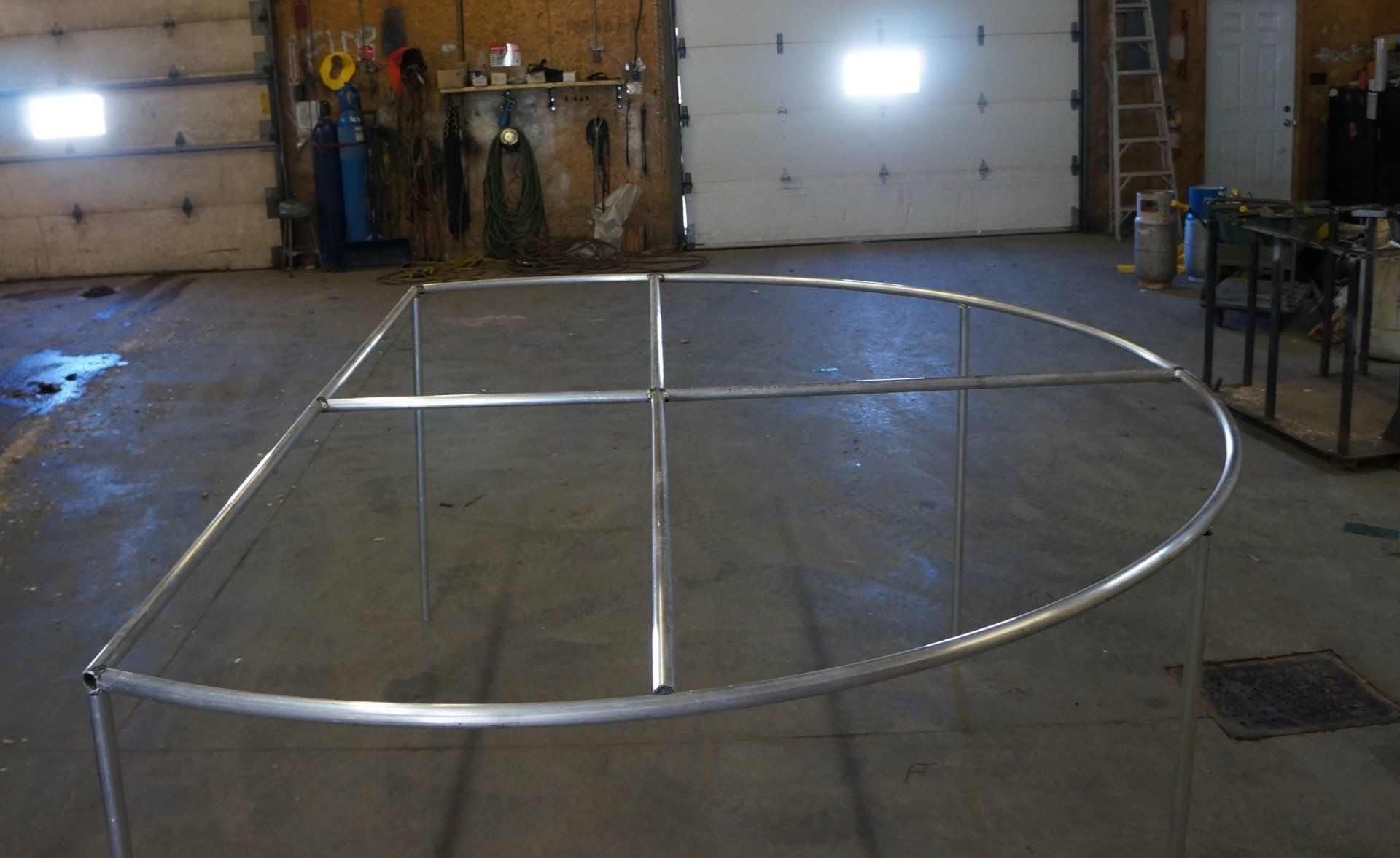 A metal frame is sitting in a warehouse next to a garage door.