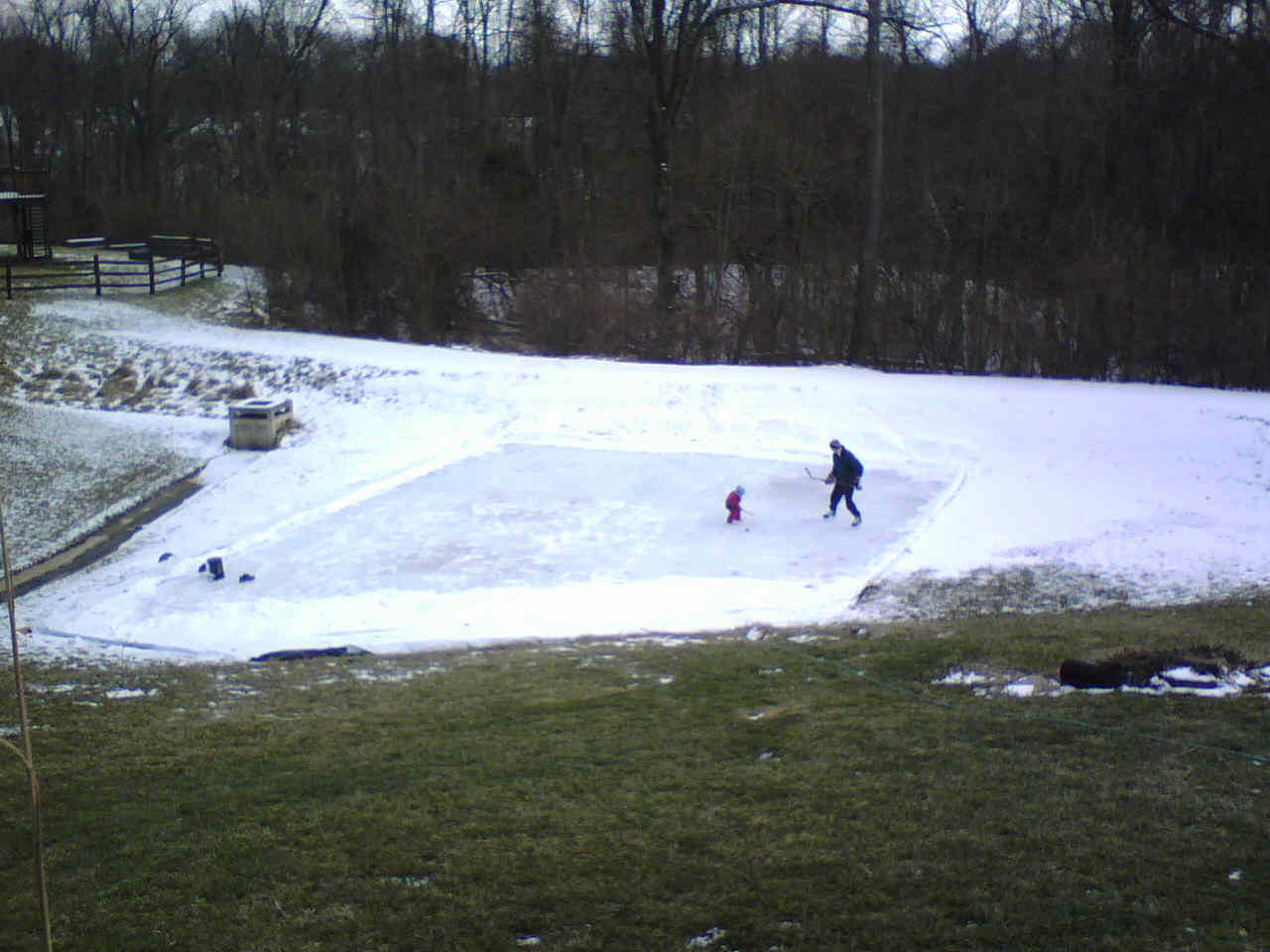 A man and two children are playing in the snow