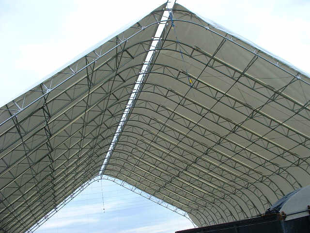 The roof of a large building with a white tarp on it