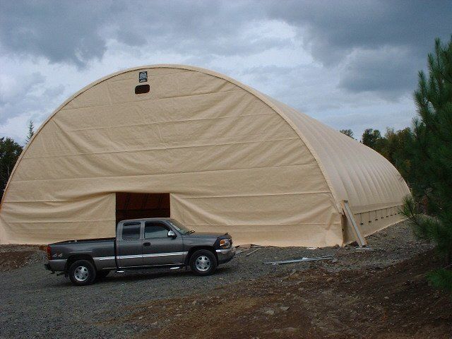 A truck is parked in front of a large tent
