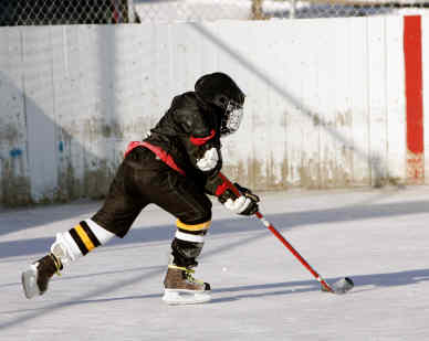 A young boy is playing ice hockey on a rink.