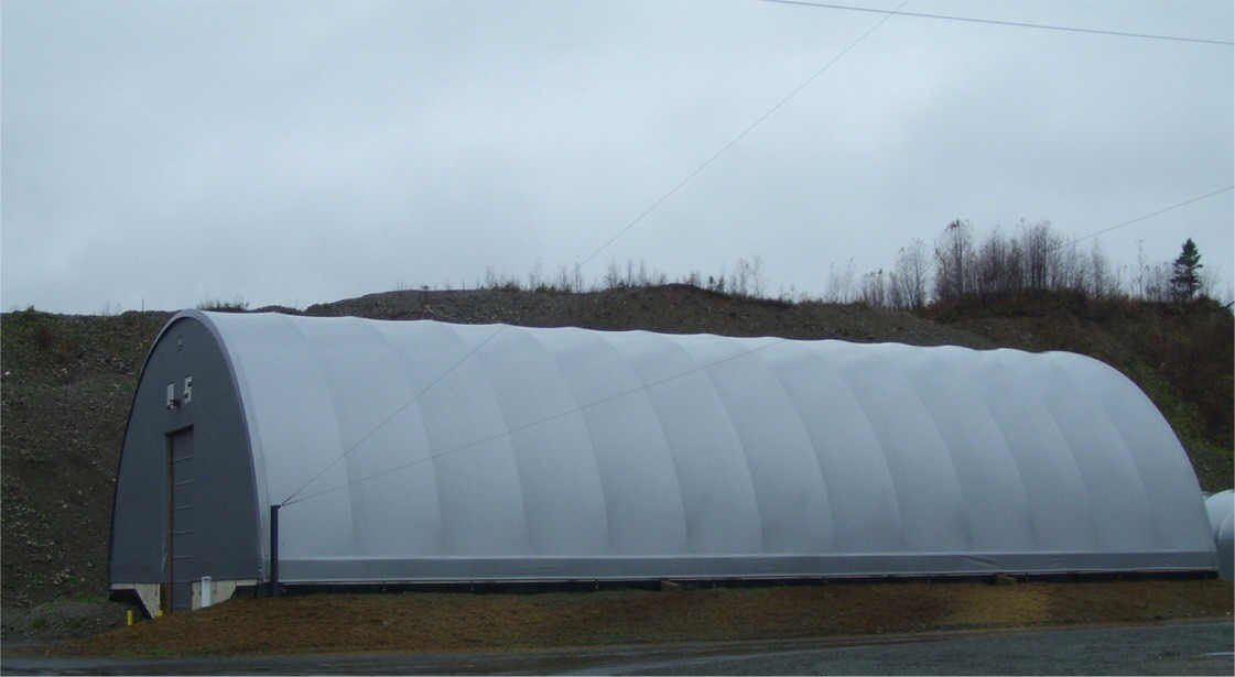 A large white building is sitting on the side of the road.