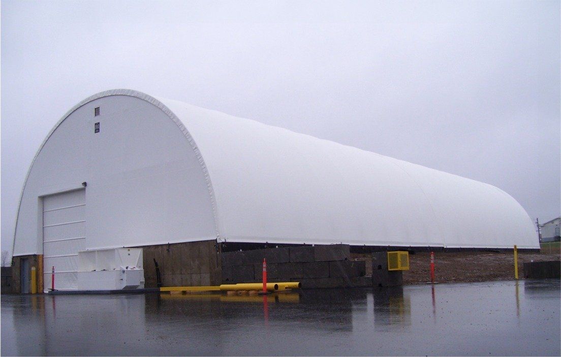 A large white building is sitting in the middle of a parking lot.