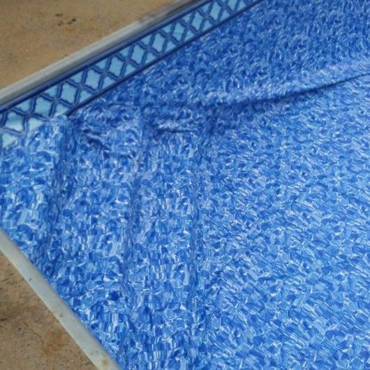 Blue pool liner with water ripples inside a pool.