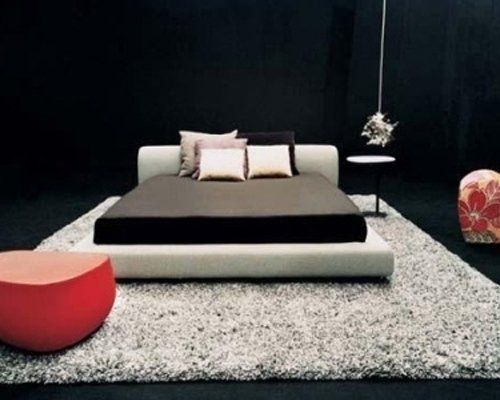 un letto matrimoniale su tappeto grigio