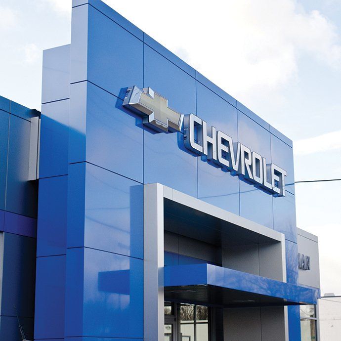 Blue Chevrolet dealership exterior with silver logo and text.