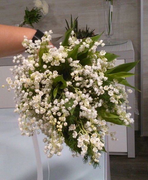 Mano consegnando un mazzo di fiori bianche