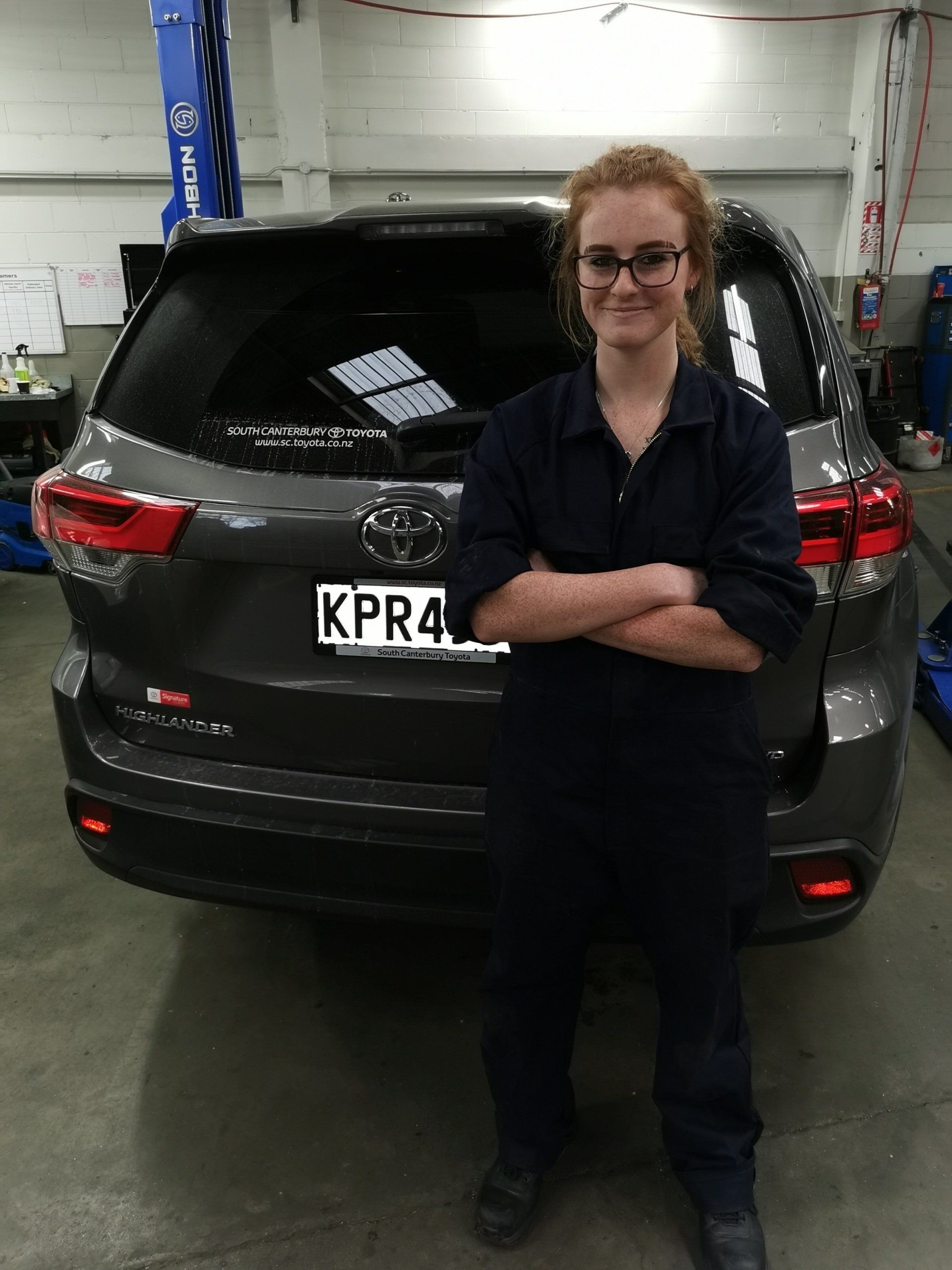 Timaru Girls Hig School | A woman is standing in front of a car with a license plate that says kpr4