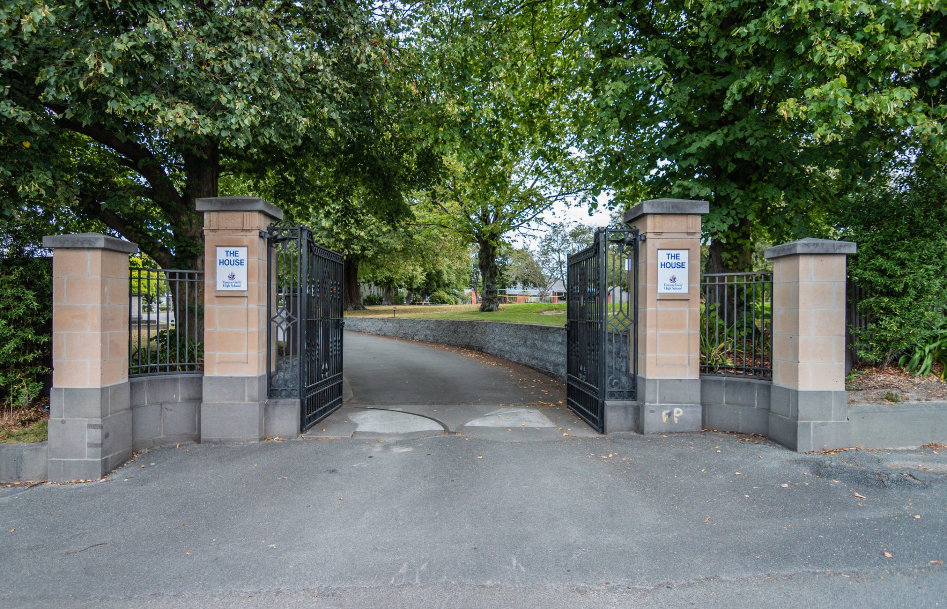 A gated entrance to a park with trees in the background
