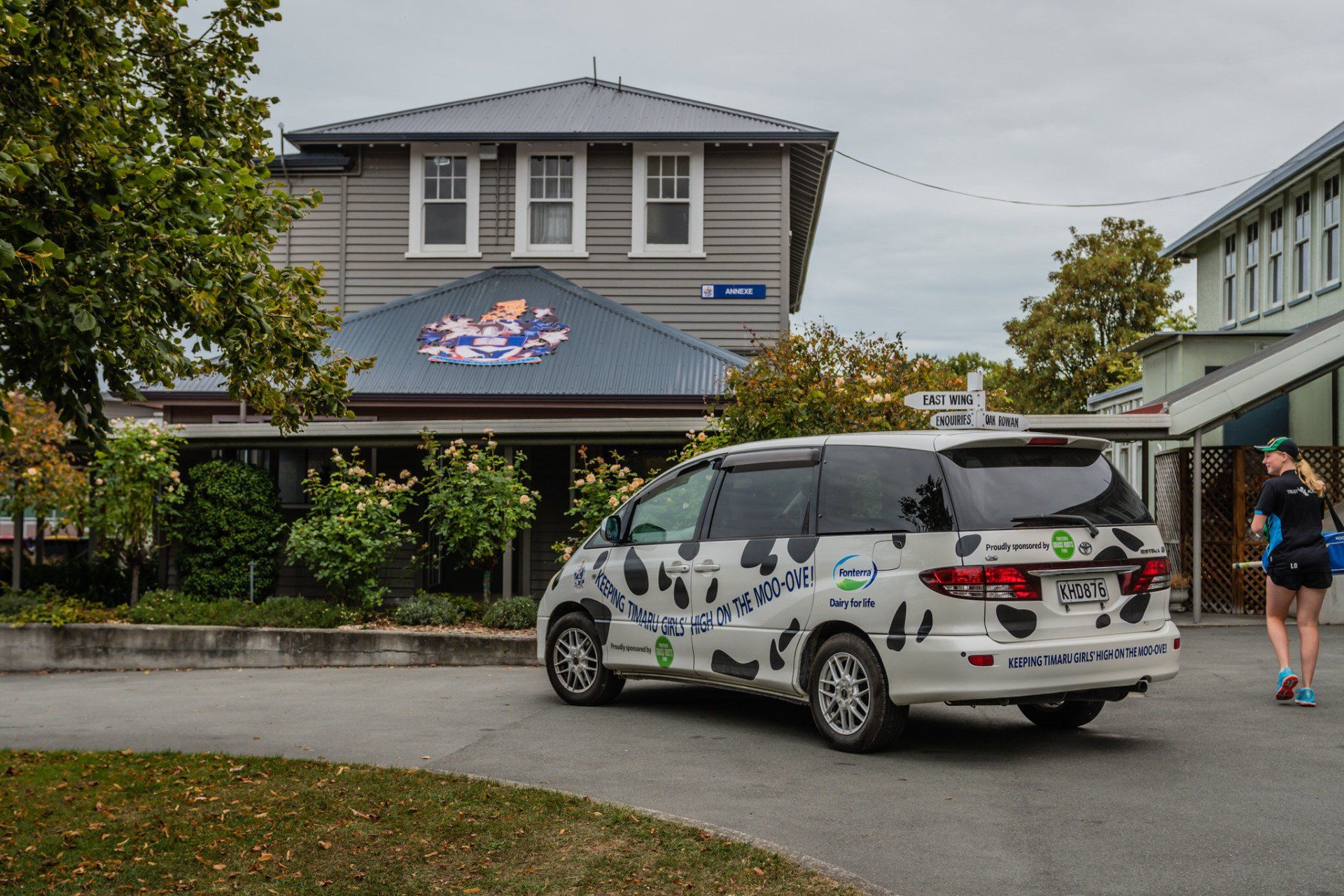 Timaru Girls Hig School | A white van with cow print on the side is parked in front of a house.