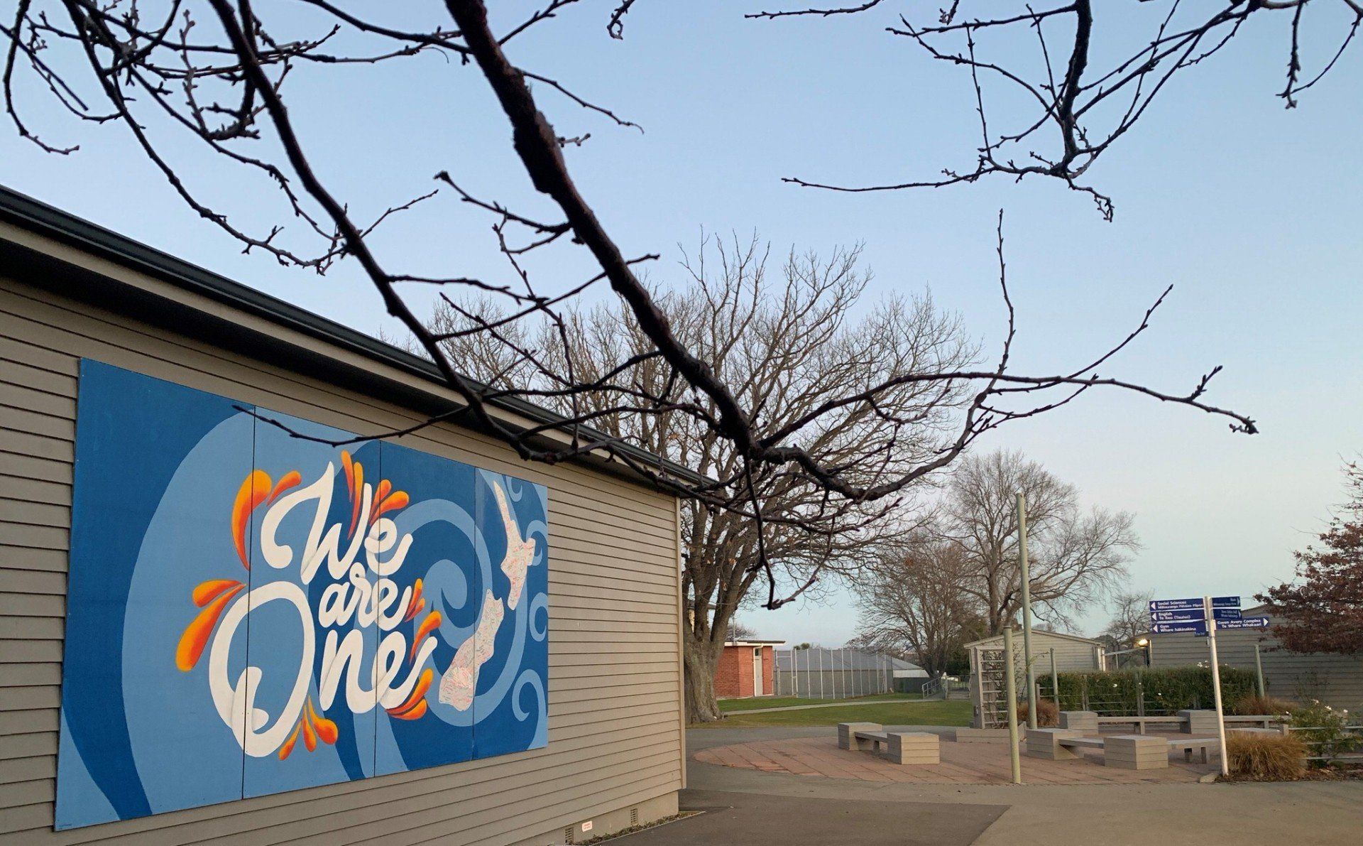 A sign on the side of a building that says we are one