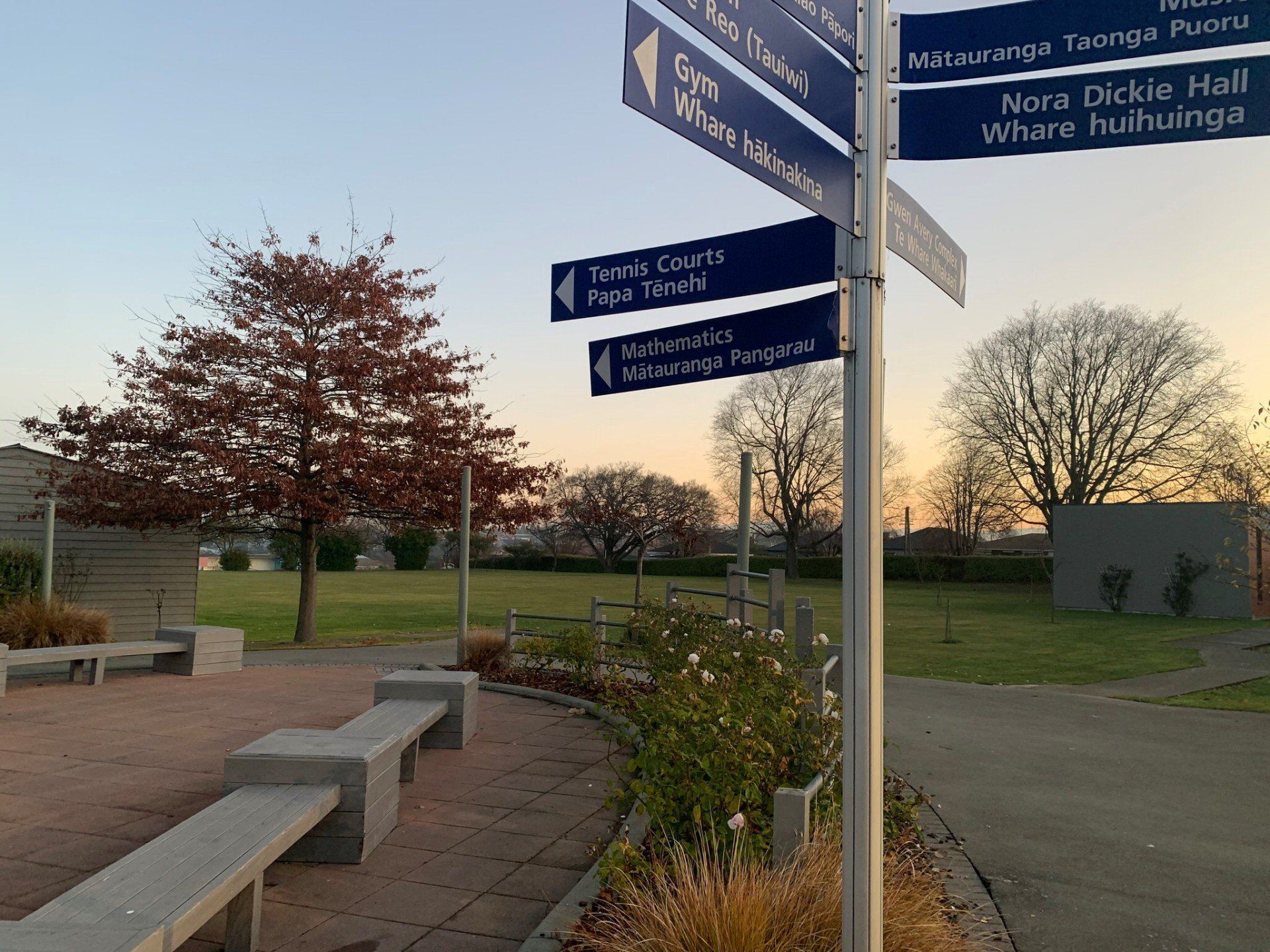 A sign in a park shows the directions to various places.