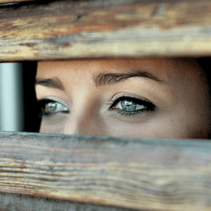 occhi attraverso una finestra in legno