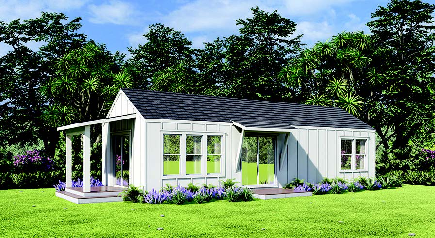 White cottage ADU with covered porch, windows, and dark roof, set on a green lawn with trees.