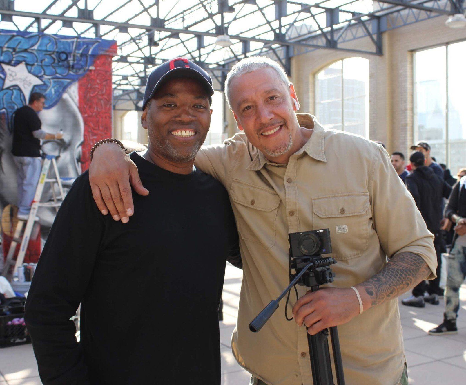 Two smiling men embracing at Rooftop Legends event
