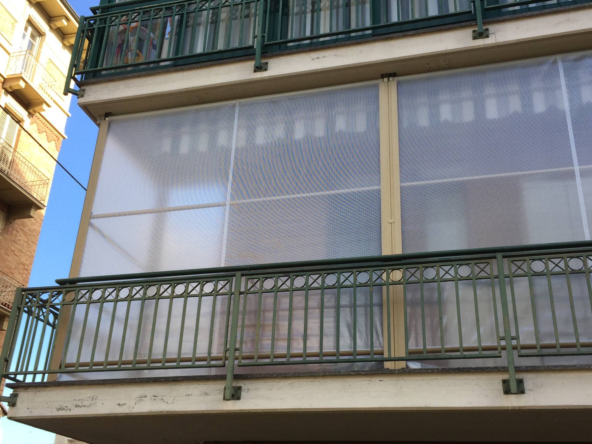 Balcone con ringhiera in metallo e tende a guide invernali