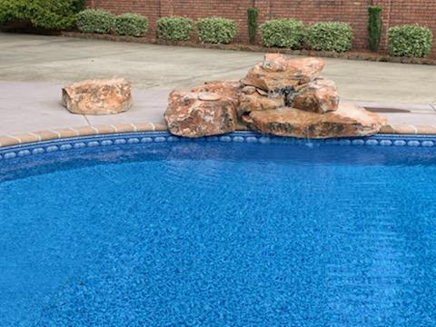 Inground pool with rock formation on side
